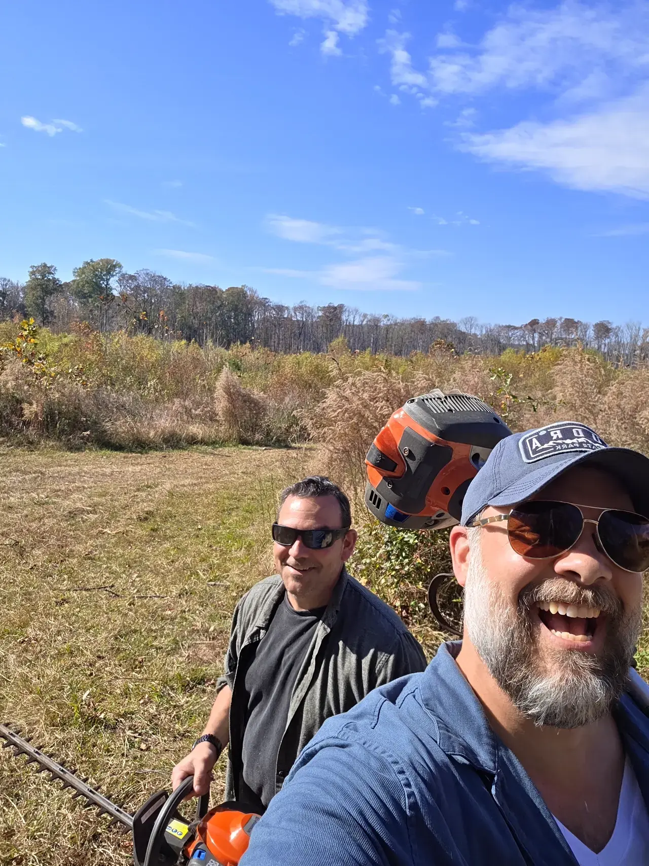 Crew members with chainsaws in open field